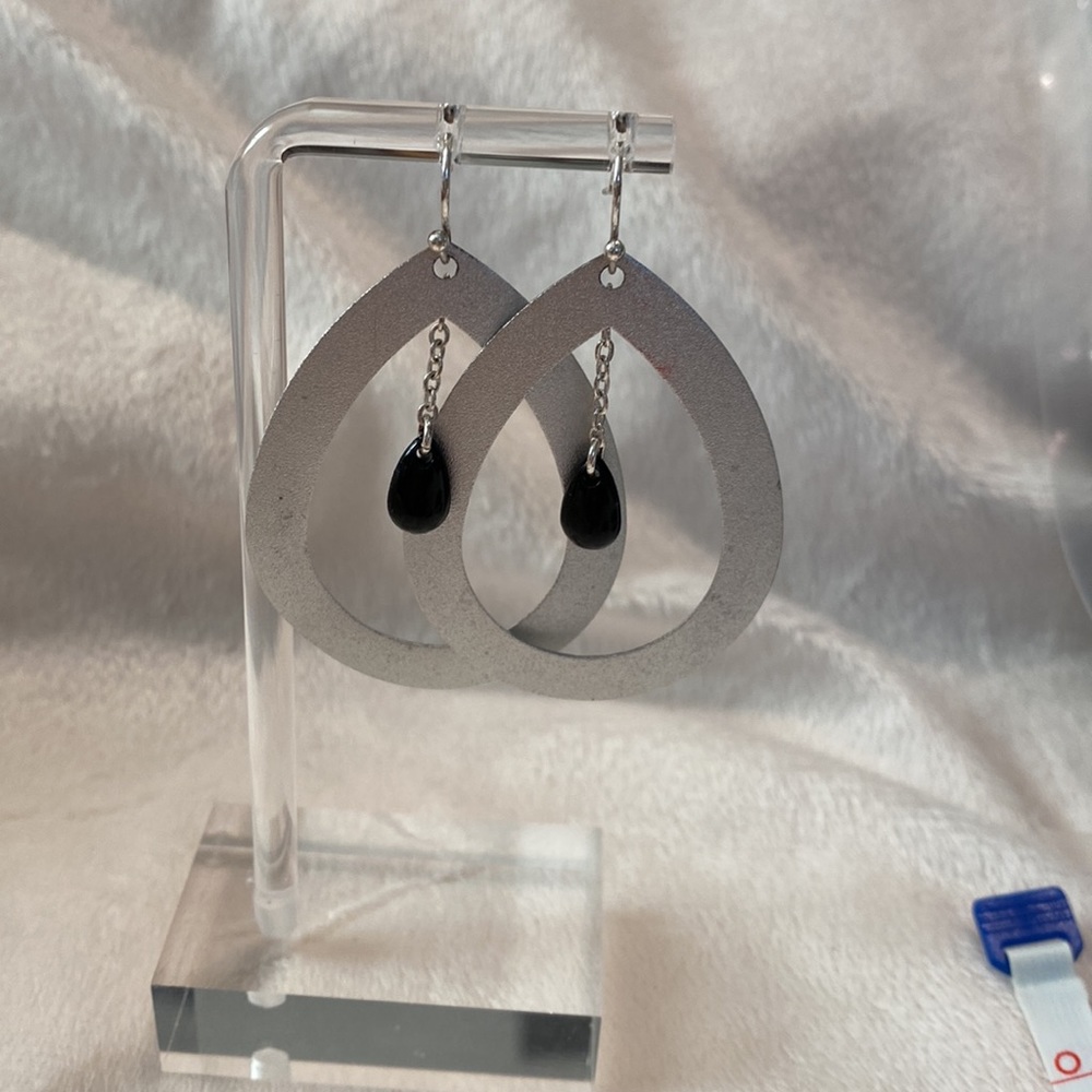 Silver teardrop earrings with black oval drop bead on a chain.